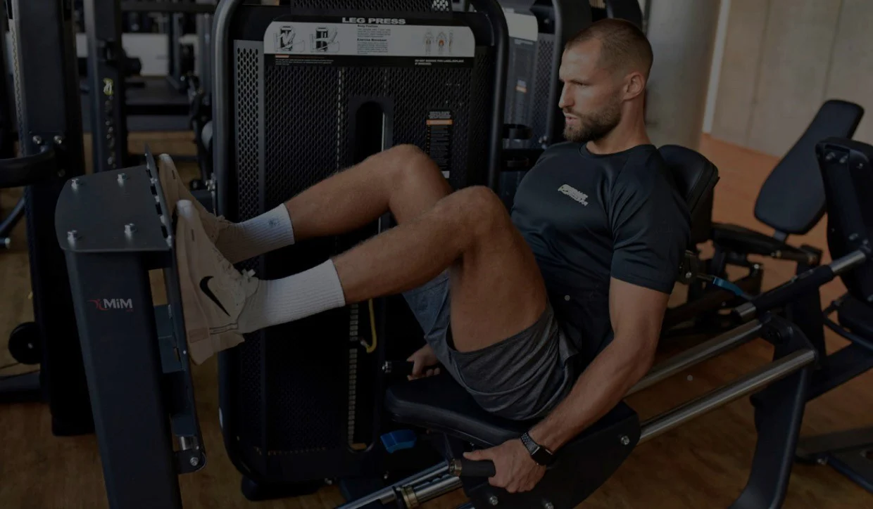 Man exercising on leg press machine at gym