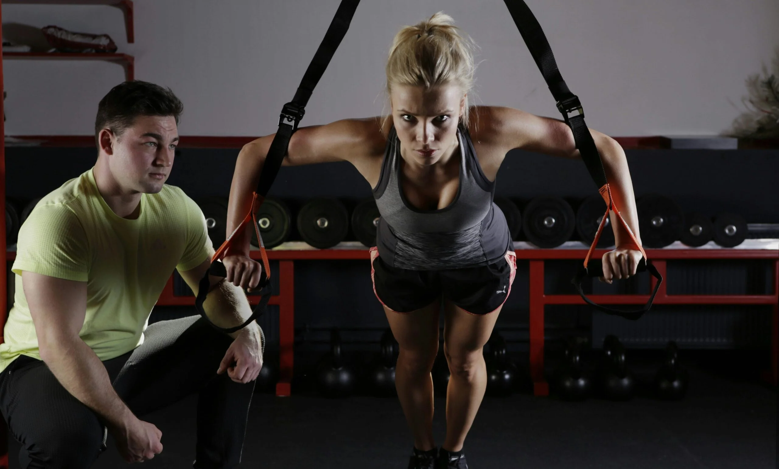 Woman training with suspension straps in gym